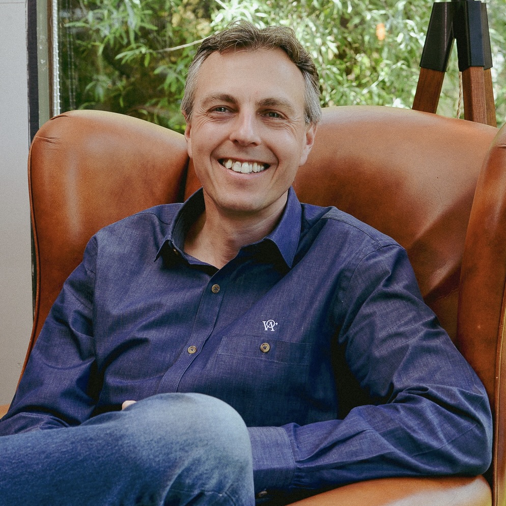 Justin-Neale-Armchair-Square Justin Neale, founder of the Value Alchemists sitting in a brown leather armchair smiling. He is wearing a blue shirt with the Value Alchemists logo above the breast pocket