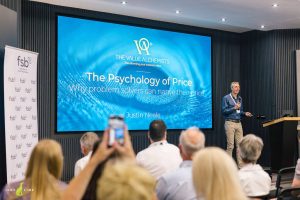 Justin Neale presenting the Psychology of Price on stage